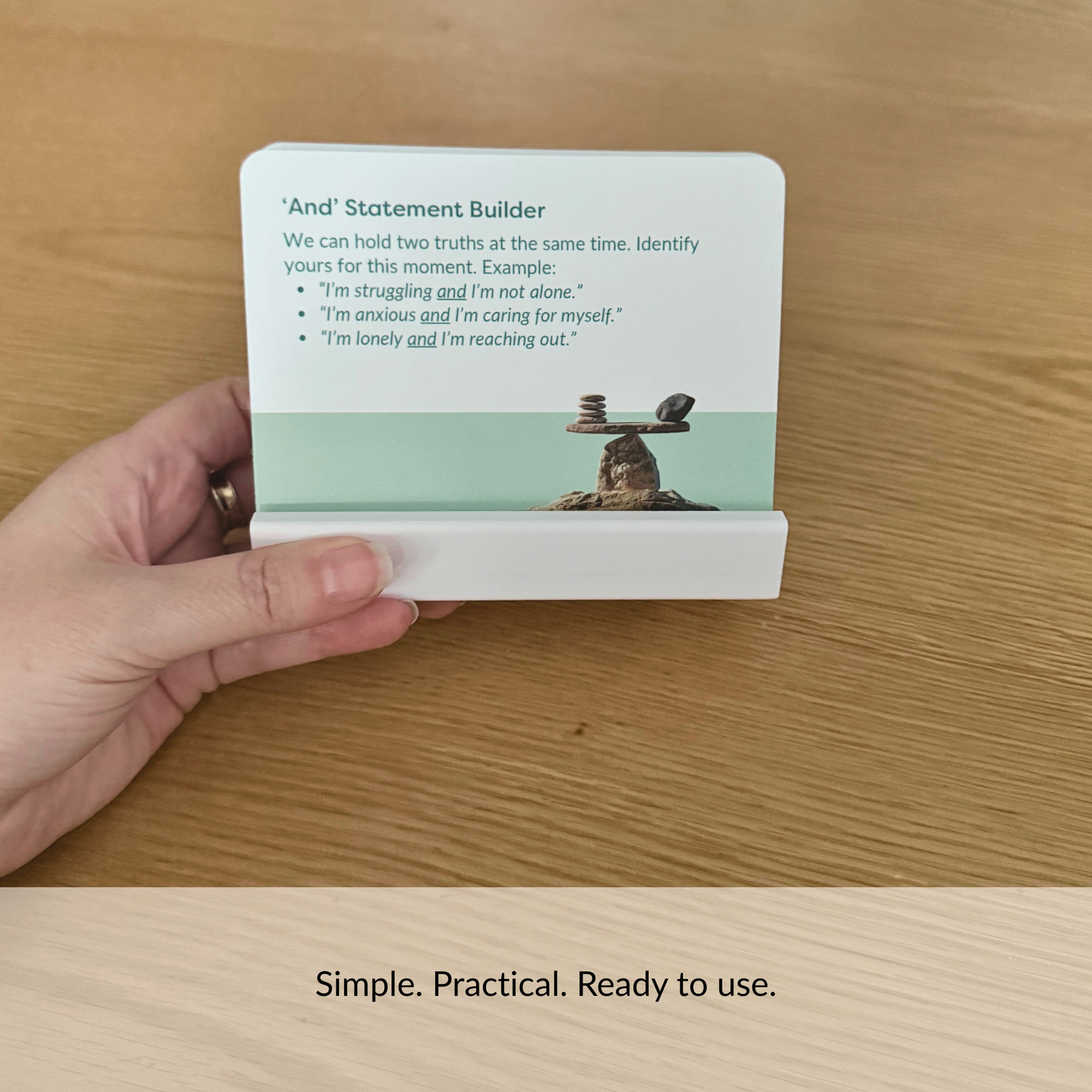 Hand holding a Calm Cards display stand with card inserted to show size, portability and ease of use